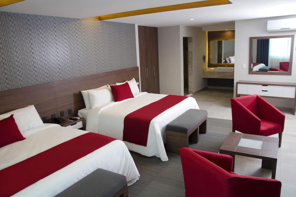 Une chambre d’hôtel avec deux lits, un bureau, une chaise et un miroir.