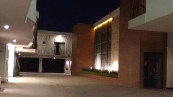 Un edificio moderno con estacionamiento techado y una entrada bien iluminada.