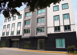 A modern hotel building with multiple floors, balconies, and a prominent entrance. - Hotel 5 de Mayo (Puebla)