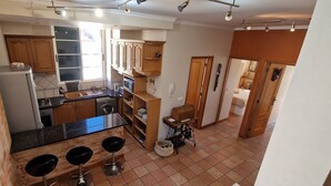 Une cuisine avec des meubles de rangement en bois, un évier, une cuisinière et une fenêtre.