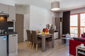 A compact living space with a kitchenette, dining area, and a balcony. - Chalet in Paradiski with Ski-In/Ski-Out Access (Plagne Villages)