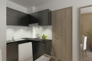 Eine moderne Küche mit dunklen Schränken, einer weißen Arbeitsplatte und einer Holztür.