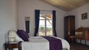 A bedroom with a bed, a nightstand, a desk, and a wardrobe. - Le Domaine des Ravels, 4-star charm and comfort, calm and relaxation in the countryside (Cause-De-Clérans)