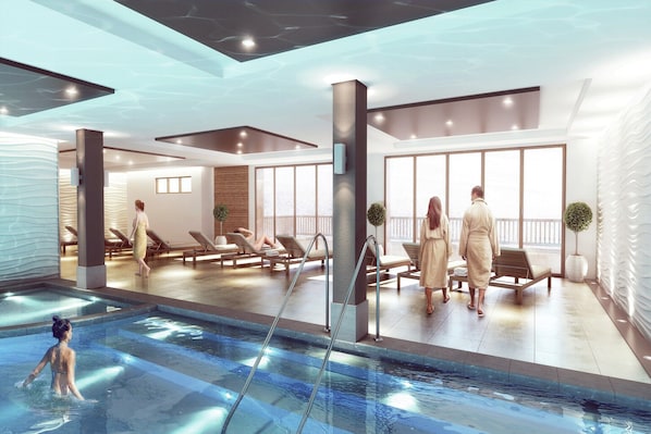 A modern indoor swimming pool area with lounge chairs, a pool, and large windows.