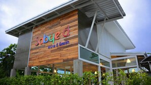 A modern building with a wooden facade and a sign that reads "Sabyed." - Sabye D Resort at Surat (Surat Thani)