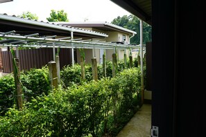 A garden with a drying rack and a wooden fence. - Phumipat Resort Thungsong (Thung Song)