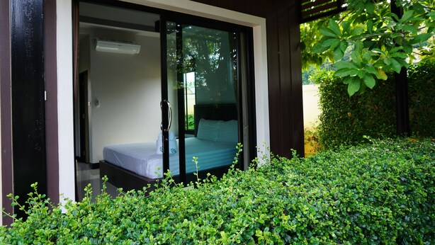 Una habitación con una cama, una ventana y una puerta que da al exterior.