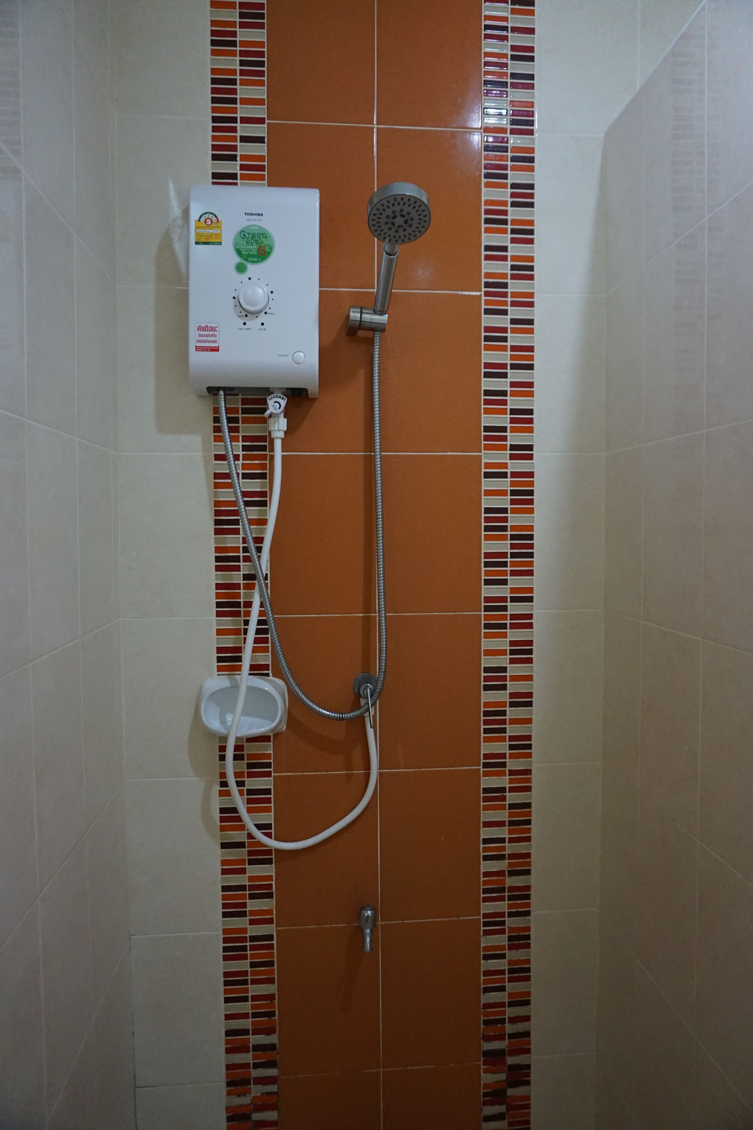 A shower with a control panel, a handheld showerhead, and a handheld basin.