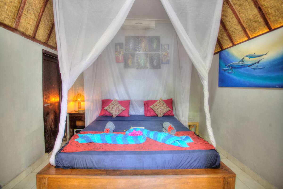 A bed with a canopy, a nightstand, and a painting on the wall.
