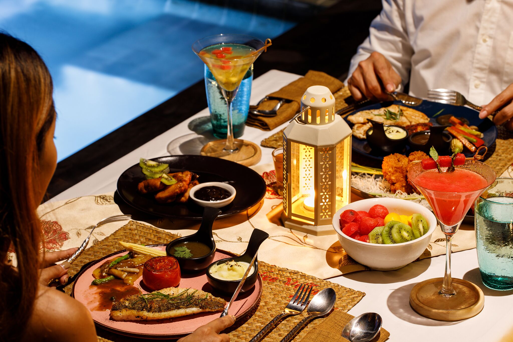 A dining table with various dishes, drinks, and a decorative lantern.