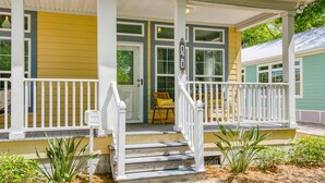 A two-story house with a porch, a front door, and a mailbox.