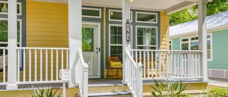 A two-story house with a porch, a front door, and a mailbox.