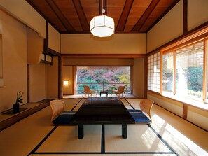 A traditional Japanese room with tatami flooring, a low table, and sliding doors.