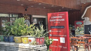 A red signboard for Longzhu Guesthouse with contact details and a starting price of 799 Bath. - Longzhu Guesthouse (Bangkok)