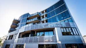 A modern multi-story building with large glass windows and balconies. - Anchorage Apartments Hampton (Hampton)
