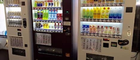 Three beverage vending machines with various drink options.