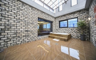 Un interior moderno con paredes de ladrillo visto, techo de cristal y un banco de madera.