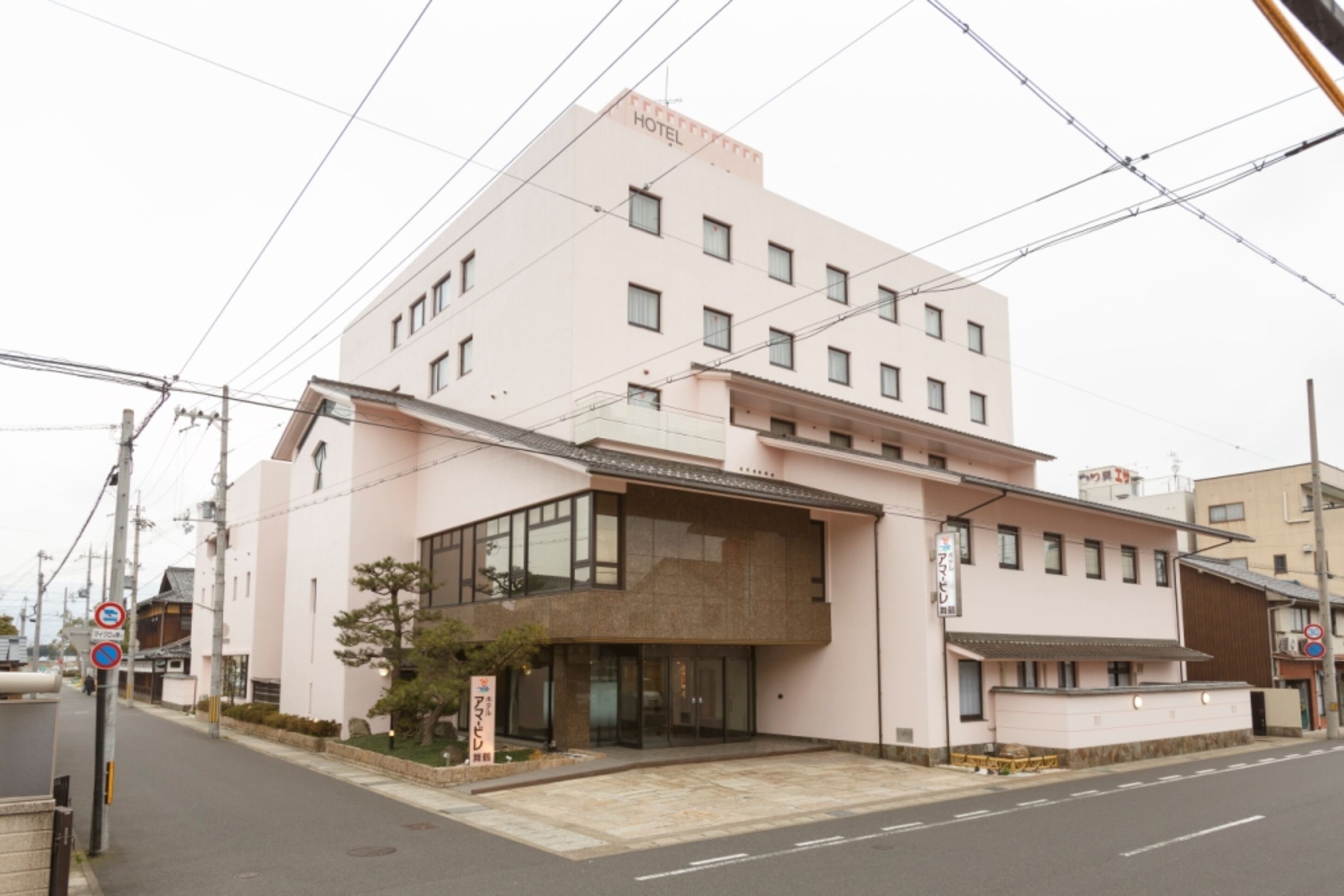 Um hotel rosa com vários andares, janelas amplas e design moderno.