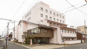 Um hotel rosa com vários andares, janelas amplas e design moderno.