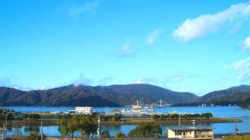 A coastal town with buildings near a body of water, surrounded by mountains.