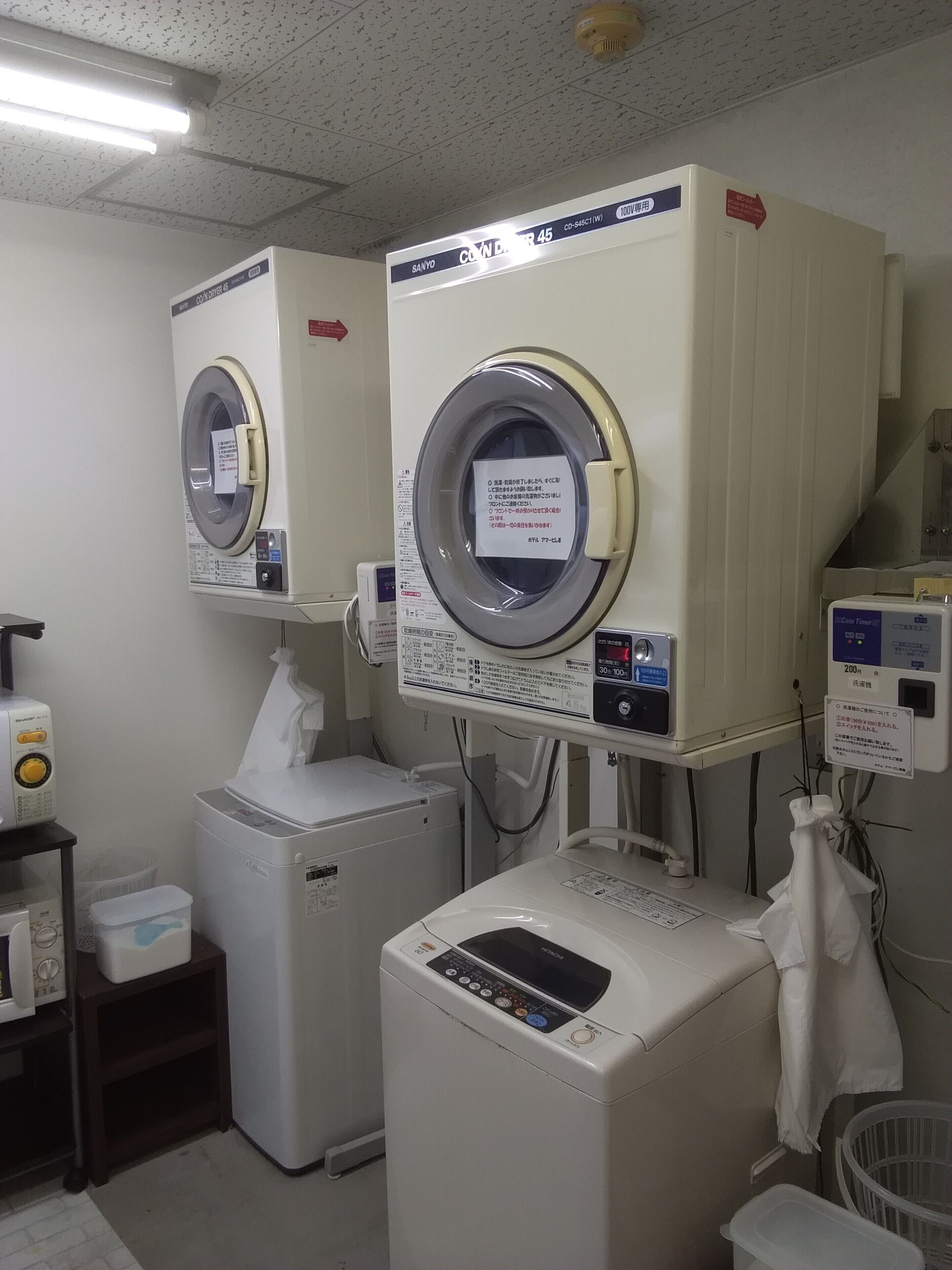 A laundry room with two front-loading washing machines and a dryer.