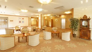 A hotel lobby with multiple seating areas, a large clock, and framed artwork on the walls. - Hotel Amabile Maizuru (Maizuru)