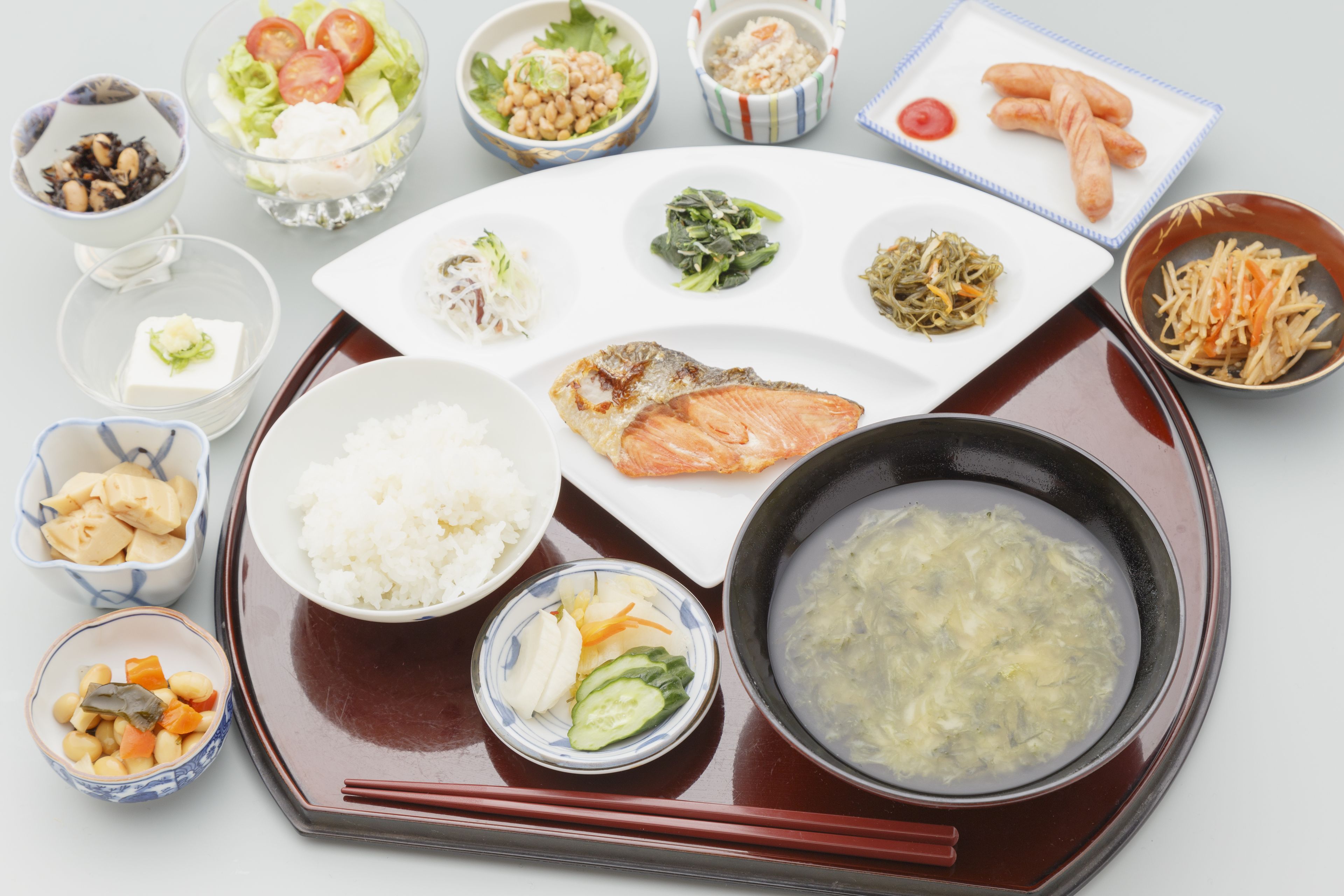 Una comida tradicional japonesa con arroz, pescado y diferentes guarniciones sobre una bandeja.