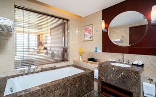 Un bagno moderno con una vasca da bagno ampia, due lavandini e uno specchio grande.