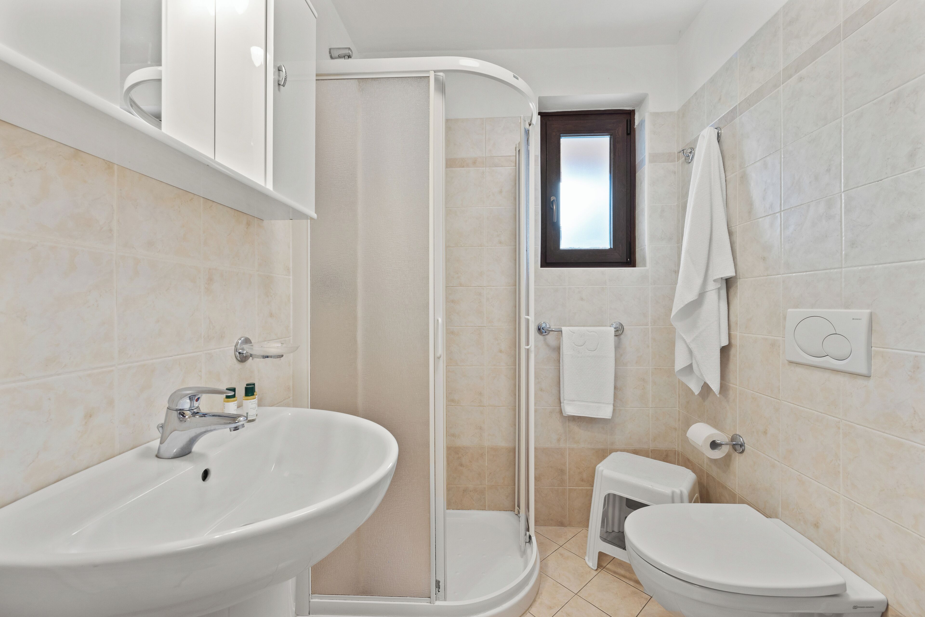 A bathroom with a sink, toilet, and shower.