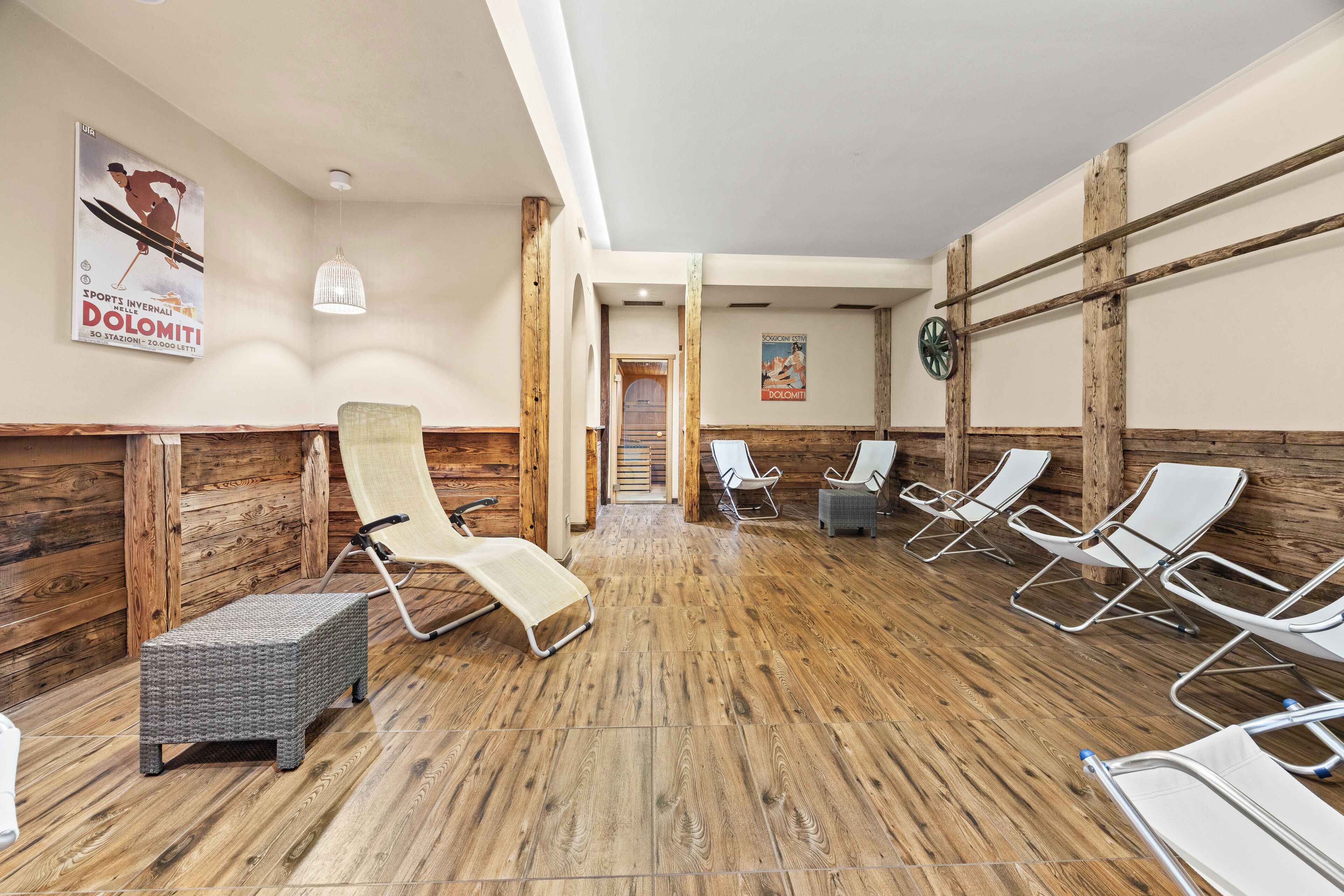 Un área de spa con paredes de madera, una camilla de masaje y varias sillas reclinables.