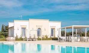 Uma villa moderna com piscina, área de estar ao ar livre e um pátio coberto.