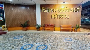 A reception area with a tiled floor, a bench, and potted plants. - Royal Land Mae Klong Hotel (Samut Songkhram)