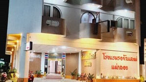 A multi-story hotel with a modern design, featuring balconies on each floor and a well-lit entrance. - Royal Land Mae Klong Hotel (Samut Songkhram)