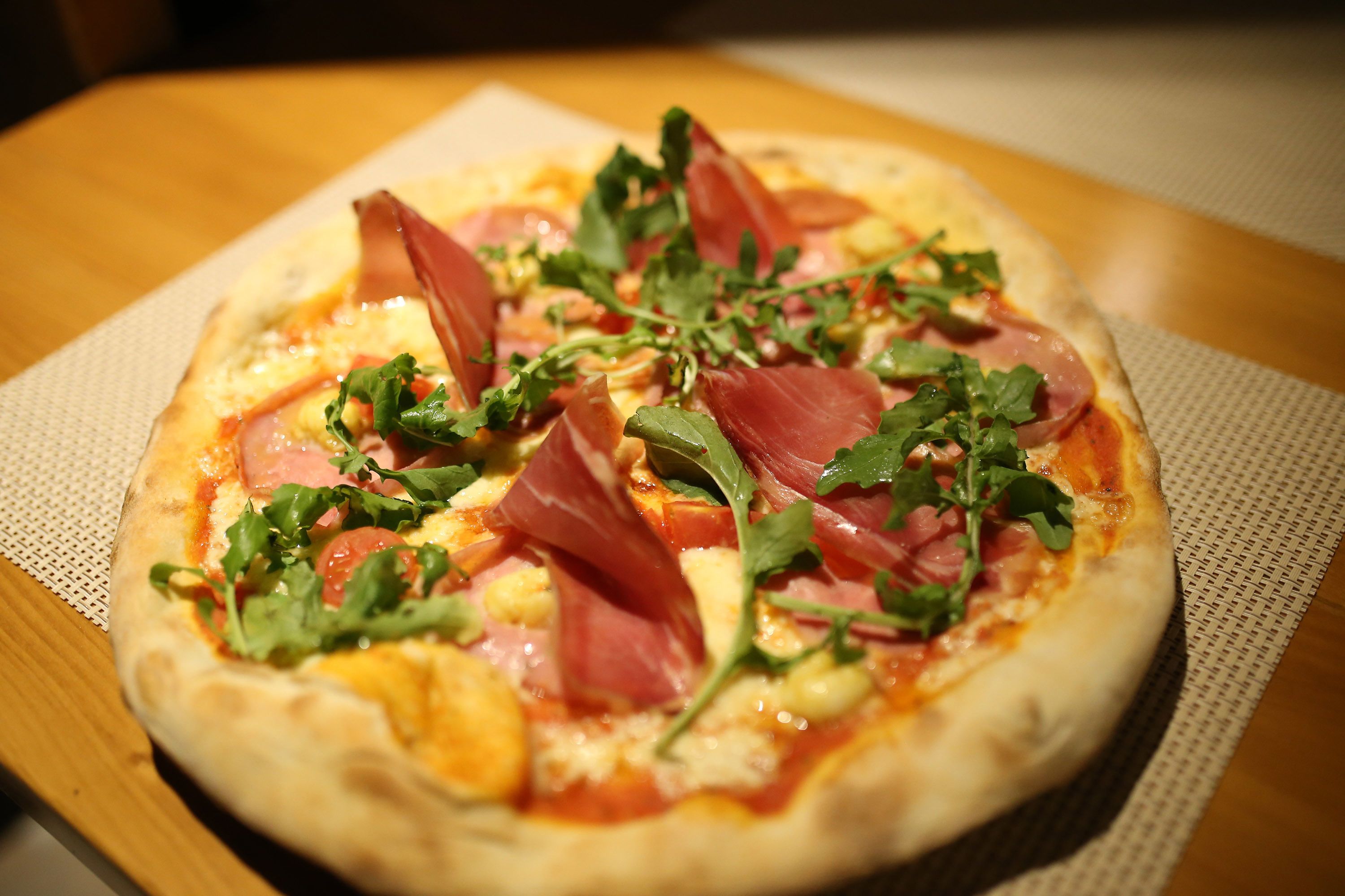 A pizza with various toppings on a wooden table.