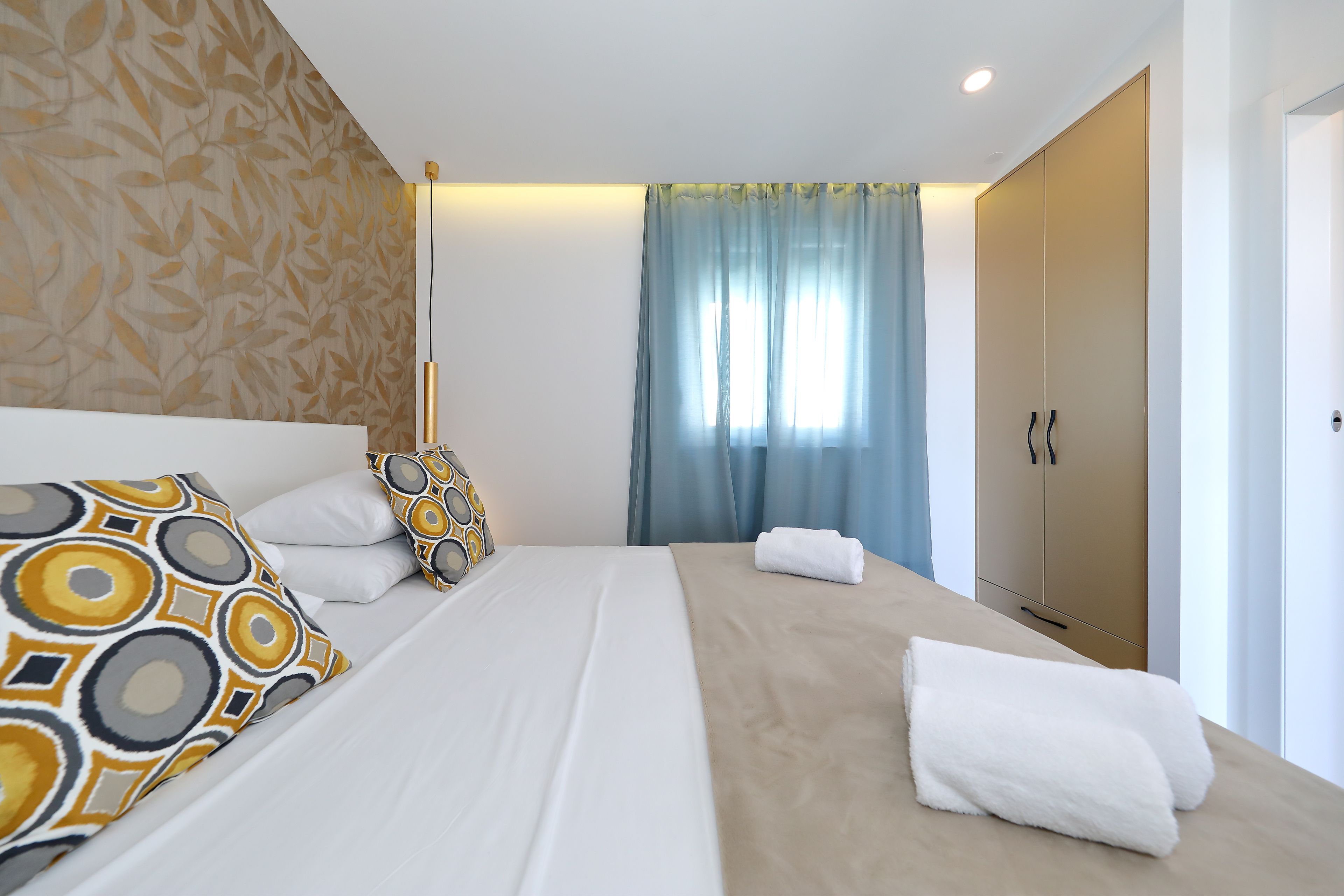 Een hotelkamer met een bed, een kledingkast en een raam met gordijnen.