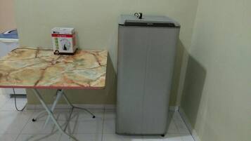A small room with a table and a refrigerator.