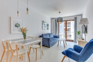 Apartemen Deluks, 1 kamar tidur, balkon, pemandangan sungai (Chmielna 73/85) | Ruang keluarga | Televisi layar datar 50-inci dengan saluran TV kabel dan TV