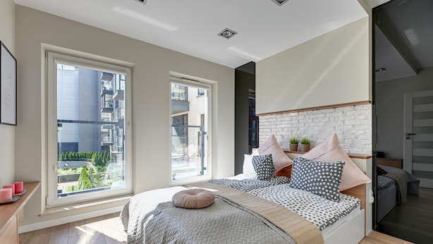 A modern bedroom with a large bed, a view of the city, and a balcony. - NORDBYHUS Apartamenty Chmielna Park (Gdansk)