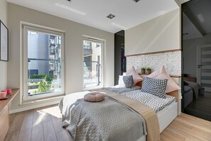 Een moderne slaapkamer met een groot bed, uitzicht op de stad en een balkon.
