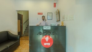 Ein Empfangstisch mit einem Schild, auf dem 'Reception' und 'OYO ROOMS' stehen.