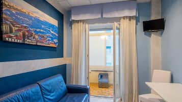 Habitación, varias camas | Área de sala de estar | Televisión de pantalla plana de 23 pulgadas con canales por cable