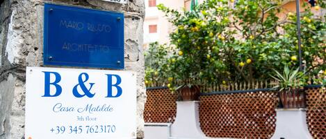 Un edificio con tre insegne: un'insegna aziendale per 'Aspes', un'insegna blu per 'Mario Russo Architect' e un'insegna bianca per 'B&B Casa Matilde'.
