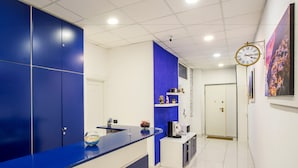 A modern kitchen with blue cabinets, a white countertop, a microwave, and a sink. - Casa Matilde (Sorrento)
