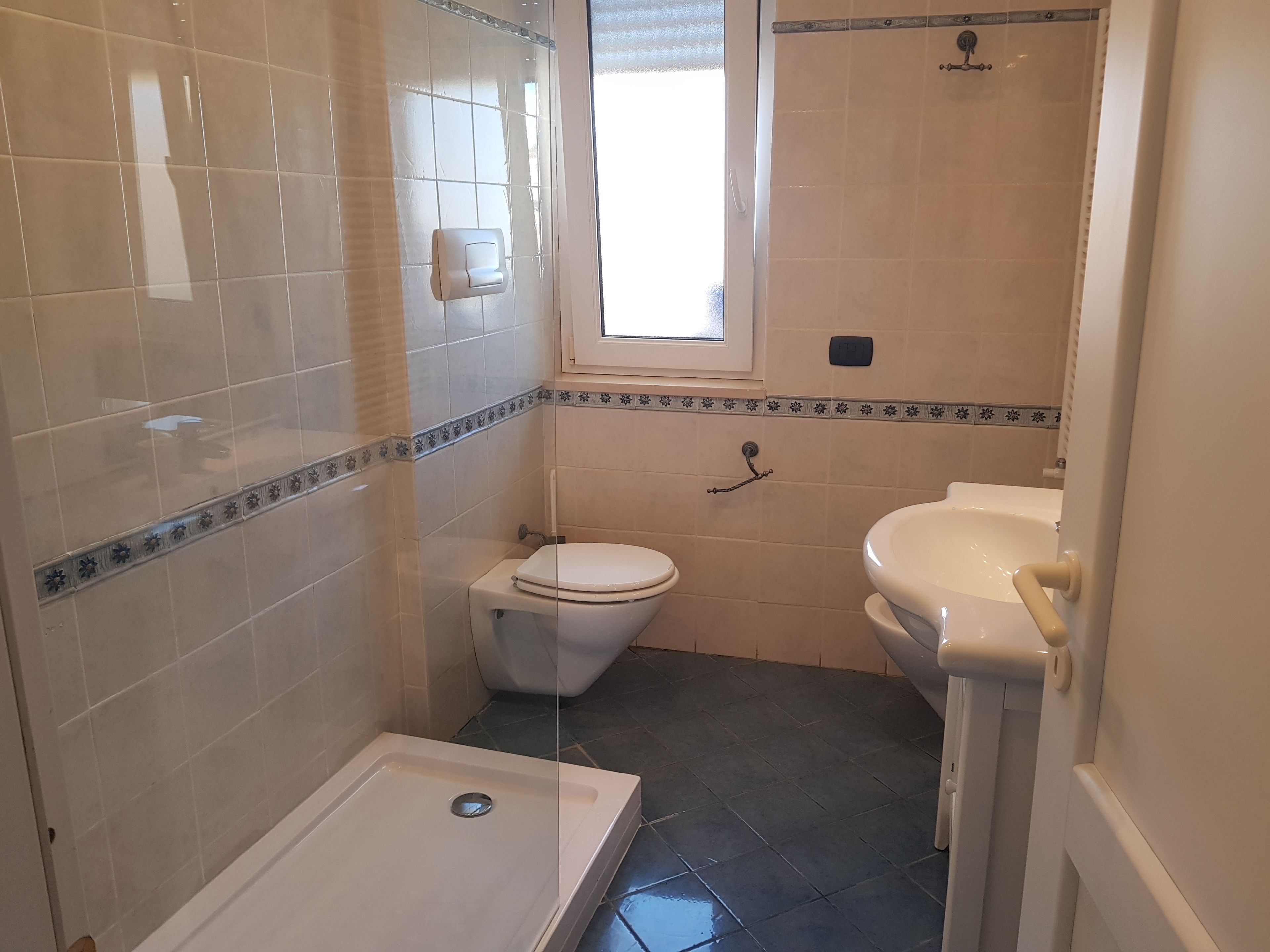 Un baño con inodoro, lavabo y ducha.
