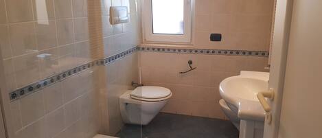 Un baño con inodoro, lavabo y ducha.