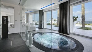 A modern spa area with a hot tub, large windows, and a view of the outdoors. - Soleinme Resort (Ostuni)