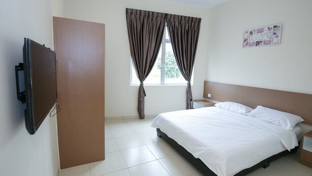 A hotel room with a bed, a TV, a wooden door, and a window with curtains. - DS Hotel (Gemas)