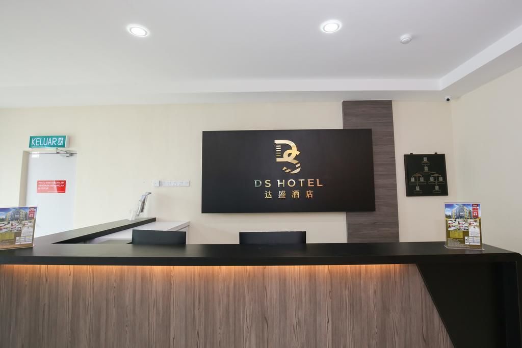 A hotel reception desk with a sign reading "DS HOTEL" and a sign for "KELUAR" in the background.