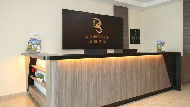 Een receptiebalie van een hotel met een modern design, met een logo en naam in zowel Engels als Chinees.