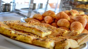 A breakfast buffet with a variety of pastries and a large omelette.